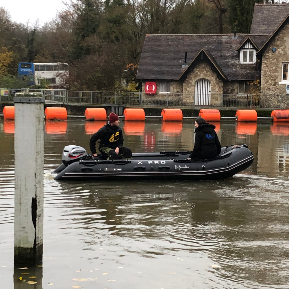 Commercial Safety Boat operating in a river running through a town.